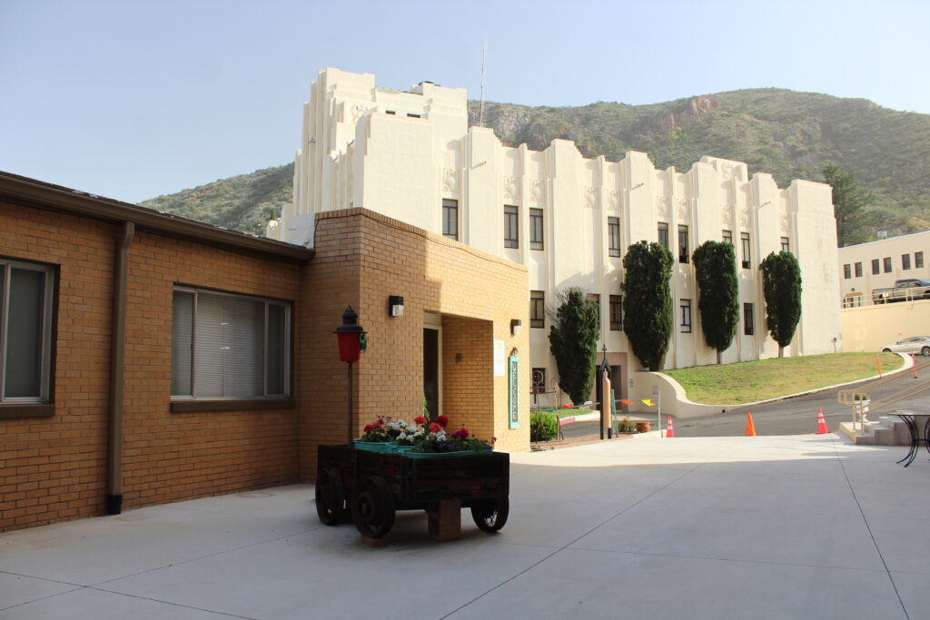county courthouse in Bisbee arizona, with extremely white surfaces in the art deco style, as viewed from next door'a catholic church